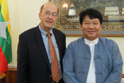 Fogarty Director Dr Roger I Glass stands with Burma's health minister Dr Pe Thet Khin, Burmese flag in background