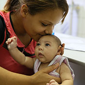 Photo by Harold Ruiz/PAHO-WHO. In Brazil, a mother kisses a baby, who has a smaller than usual head