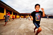 Children happily run and play outside in a school courtyard