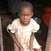 Young girl standing on the doorstep in a doorway holds a large bowl