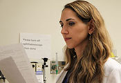 Dr. Laura Lewandowski reviews printouts in a medical exam room
