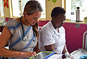 Photo by Sarah Graham. Dr. Lisa Bebell works with research nurse Honest Twinomujuni to record data in a clinic.