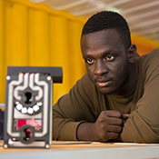 Photo courtesy of Royal Academy of Engineering. Brian Gitta observes a malaria detection prototype.