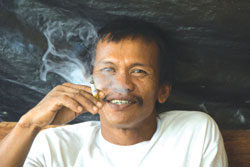 Photo: Indonesian man smokes a cigarette