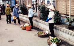 Photo: Vendors along the street in Vietnam wearing handkerchiefs tied over their mouths and noses