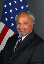 Headshot of Eric Goosby, US flag in background