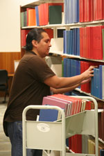 Photo: A man removes bound medical journals from shelves at the NIH library