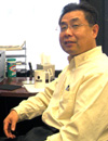 Dr. Xingzhu Liu sitting at his desk.