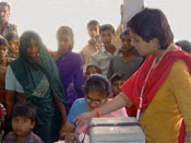 Photo: Dr. Manisha Nair speaks and gestures to a crowd of Indian children and adults