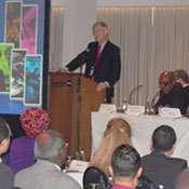 Dr Francis Collins speaks at a podium in front of full conference room