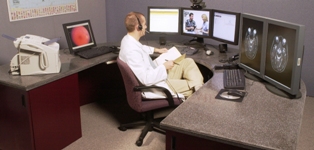 A man sits in front of five computer screens while listening with headphones. Photo: UTMB