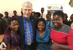 NIH Director Francis Collins poses for the camera with three young women in Uganda