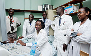 Medical student works with a patient, teacher and other students observe