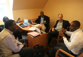 Five men in an office collaborate and discuss in an office at the Center for Global Health Studies