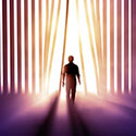 Silhouette of person walking through vertical blinds toward a bright light