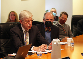 Dr. Francis Collins (left) speaks as Dr. Peter Kilmarx (right) and others listen in.