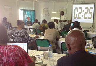 Man speaks to conference room full of people as a part of a training session