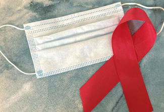 Photo of an AIDS ribbon next to a surgical mask. Photo credit: NIAID