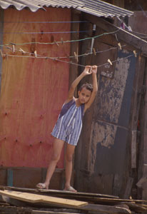 Young child hangs from empty clothesline in Brazilian slum