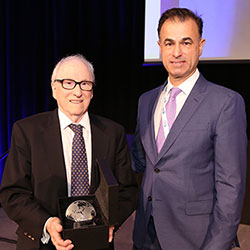 Fogarty’s Dr. Ken Bridbord, holding award, stands next to CUGH’s Dr. Keith Martin.