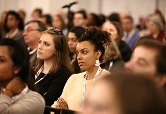 Attendees at the CUGH 2019 annual meeting listen attentively in a crowded conference room.