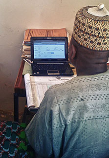 View over shoulder of man entering health data on a laptop