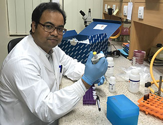 Dr. Mohammad Aminul Islam works with samples in a lab