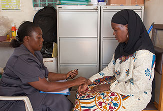 A medical worker takes the pulse of a patient in a clinic.