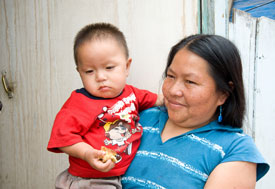 Mother holds baby, both look at camera