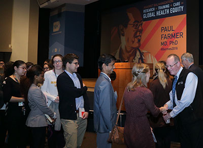 Paul Farmer shakes hands with a long line of attendees following a talk at NIH