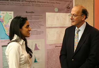 Early-career female researcher discusses her poster with Fogarty Director Dr. Roger I. Glass.