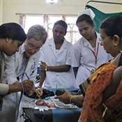 In this photo, PHRII trainees some wearing saris, learn the loop electrosurgical excision procedure for removing abnormal cervical cells from an experienced professional