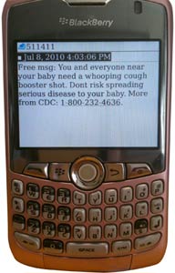 close up of Blackberry smart phone showing 5-line text message about whooping cough